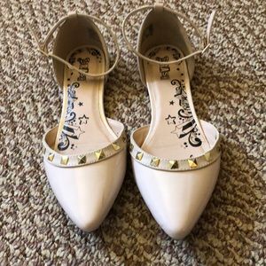 Nude flats with gold studded ankle straps.